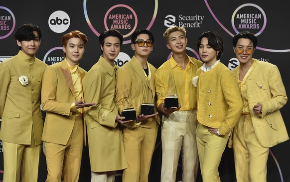 BTS poses in the press room with the awards for favorite pop duo or group and favorite pop song for "Butter" at the American Music Awards on Sunday, Nov. 21, 2021, at Microsoft Theater in Lo ...