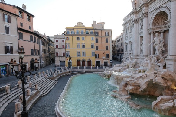 epa08316407 The Trevi Fountain is deserted during the Coronavirus emergency lockdown in Rome, Italy, 23 March 2020. Police and soldiers are deployed across the country to ensure that citizens comply w ...