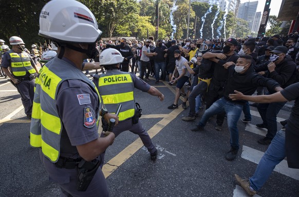 Police clash with demonstrators during a protest against fascism, President Jair Bolsonaro and to defend democracy in Sao Paulo, Brazil, Sunday, May 31, 2020. Police used tear gas to disperse anti-gov ...