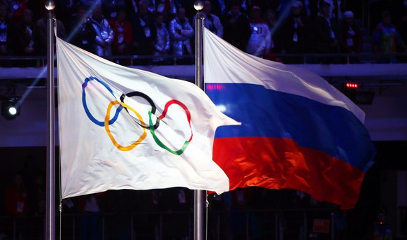 epa05439101 (FILE) A file picture dated 23 February 2014 of the Olympic flag (L) and the Russian flag (R) during the Closing Ceremony of the Sochi 2014 Olympic Games in the Fisht Olympic Stadium in So ...