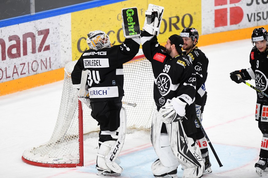 Lugano&#039;s goalkeeper Niklas Schlegel, left, celebrates the victory with Lugano&#039;s goalkeeper Sandro Zurkirchen and Lugano&#039;s player Reto Suri, during the preliminary round game of National ...