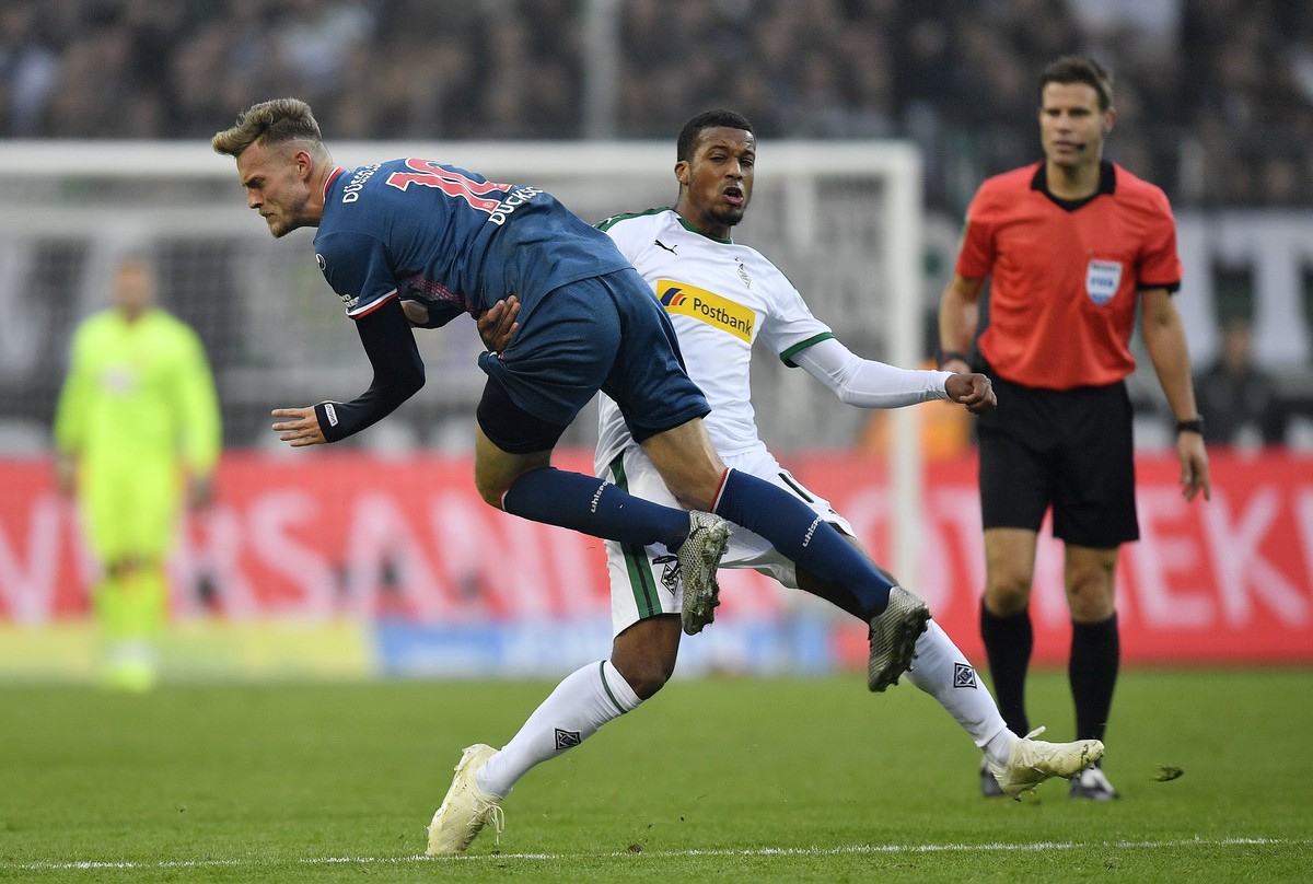 Moenchengladbach's Alassane Plea, center, fouls Duesseldorf's Marvin Ducksch during the German Bundesliga soccer match between Borussia Moenchengladbach and Fortuna Duesseldorf, Germany, Sun ...