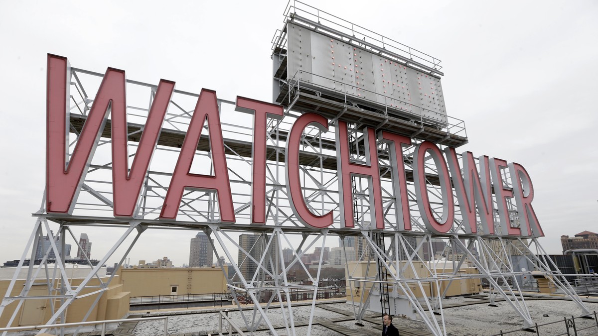 In this Wednesday, Dec. 9, 2015, photo, the iconic Watchtower sign is seen on the roof of 25-30 Columbia Heights, the current world headquarters of the Jehovah's Witnesses, in the Brooklyn boroug ...