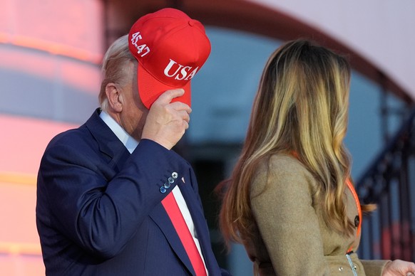 President Donald Trump, with first lady Melania Trump, adjusts his hat, as they participate in a Halloween at the White House event on the South Lawn, Thursday, Oct. 30, 2025, in Washington. (AP Photo ...