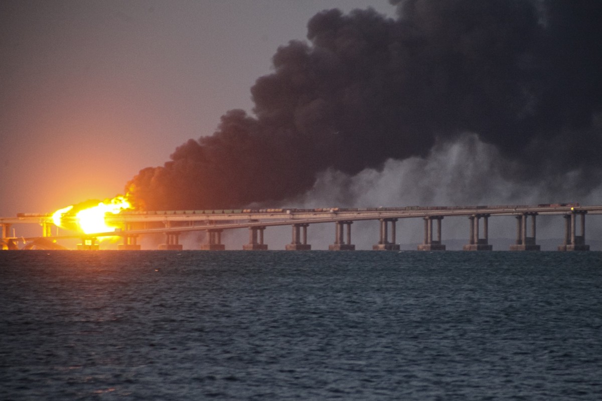 FILE - Flame and smoke rise fron Crimean Bridge connecting Russian mainland and Crimean peninsula over the Kerch Strait, in Kerch, Crimea, Saturday, Oct. 8, 2022. The Crimean Peninsula's balmy be ...
