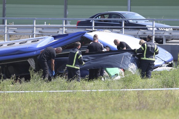 Rescuers remove a body from the wreckage of a bus at the crash scene in Podvorec, near Zagreb, Croatia, Saturday, Aug. 6, 2022. A bus with Polish license plates has skidded from a highway in northern  ...