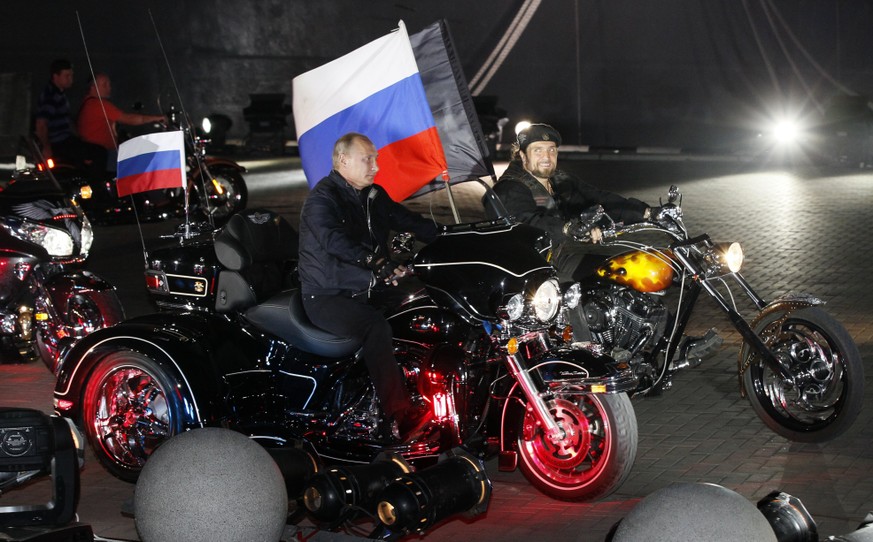 FILE - In this file photo taken on Monday, Aug. 29, 2011, then Russian Prime Minister Vladimir Putin rides three wheeler at centre, accompanied by the Night Wolves biker group leader Alexander Zaldost ...