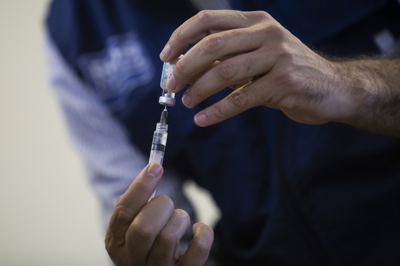 A health worker prepares a dose of the Oxford-AstraZeneca vaccine for COVID-19, as part of a priority vaccination program for people with disabilities at a vaccination center in Rio de Janeiro, Brazil ...