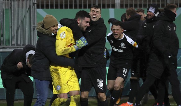 epa08936199 Kiel?s goalkeeper Ioannis Gelios (2-L) celebrates with teammates after winning the German DFB Cup second round soccer match between Holstein Kiel and FC Bayern Munich in Kiel, Germany, 13  ...