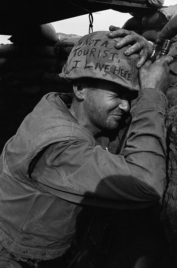 (Original Caption) Clutching helmet and weapon, Marine L/Cpl. James Jones of Pensacola, Florida, winces as Communist mortar rounds fly overhead during enemy shelling of this U.S. Marine fortresses her ...