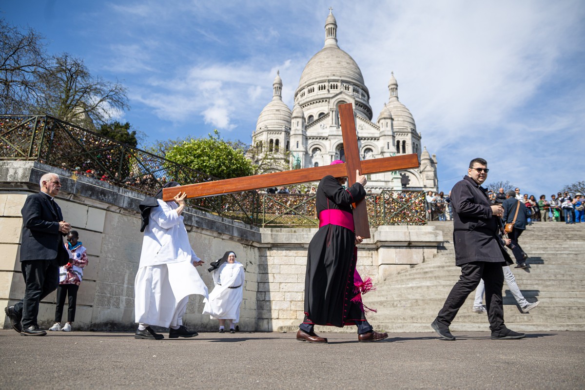 epa12039286 Archbishop of Paris Laurent Ulrich (C) leads a Stations of the Cross ceremony as part the Good Friday celebration to the Sacre-Coeur (Sacred heart) basilica atop Montmartre, overlooking Pa ...