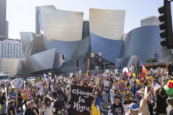 epa12463507 Protesters march by the Disney Concert Hall in Los Angeles, California, USA, 18 October 2025. The rally is part of a nationwide &#039;No Kings&#039; day of action, opposing what organizers ...