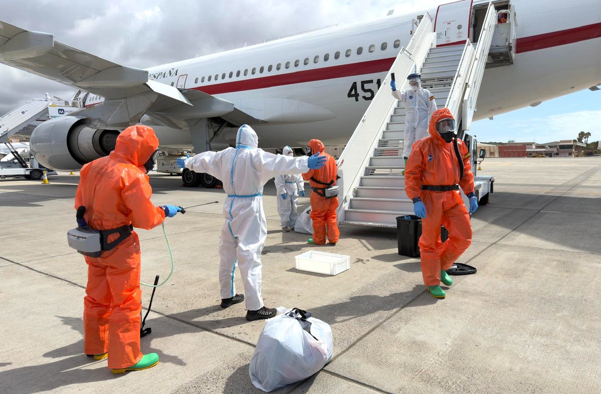 A Spanish passenger is sprayed with disinfectant by Spanish government officials before boarding a plane after disembarking from the hantavirus-stricken cruise ship MV Hondius at Tenerife airport in t ...
