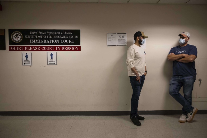 Plain clothes officers with Immigration and Customs Enforcement stand in a hallway outside an immigration courtroom at the Jacob K. Javitz Federal Building in New York, Friday, June 6, 2025. (AP Photo ...