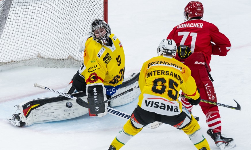 Le gardien bernois Philip Wuethrich, gauche, et le defenseur bernois Ramon Untersander, centre, luttent pour le puck avec l&#039;attaquant lausannois Cory Conacher, droite, lors du match du championna ...