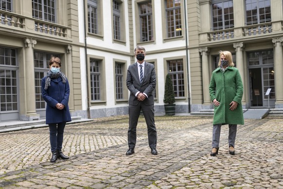 Der Berner Stadtpraesident Alec von Graffenried, Mitte, und die Gemeinderaetinnen Franziska Teuscher, links, und Marieke Kruit beachten die Schweigeminute, um der Opfer der Pandemie des Coronavirus zu ...