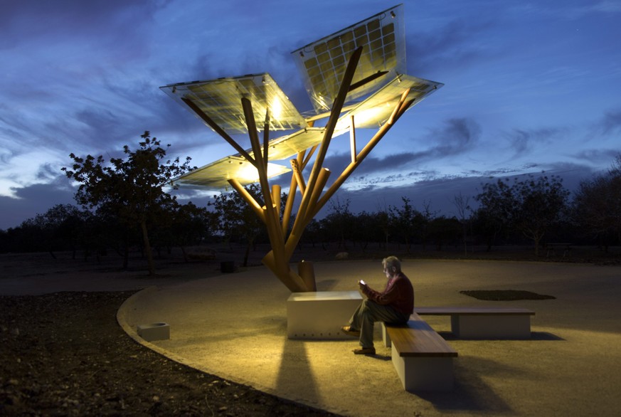 epa04458297 A man using a WiFi connection to surf the Internet provided by the eTree by the Israeli company Sologic who has placed a prototype in a park in Zichron Yacov, northern Israel, 22 October 2 ...