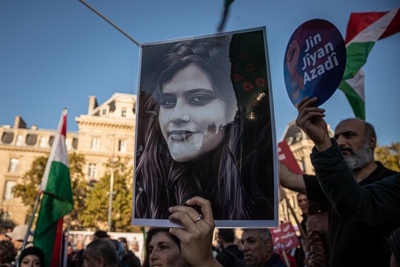 epa10233092 A woman holds a portrait of Mahsa Amini as people participate in a rally in support of Iranian women, in Paris, France, 09 October 2022. This demonstration takes place following the deaths ...