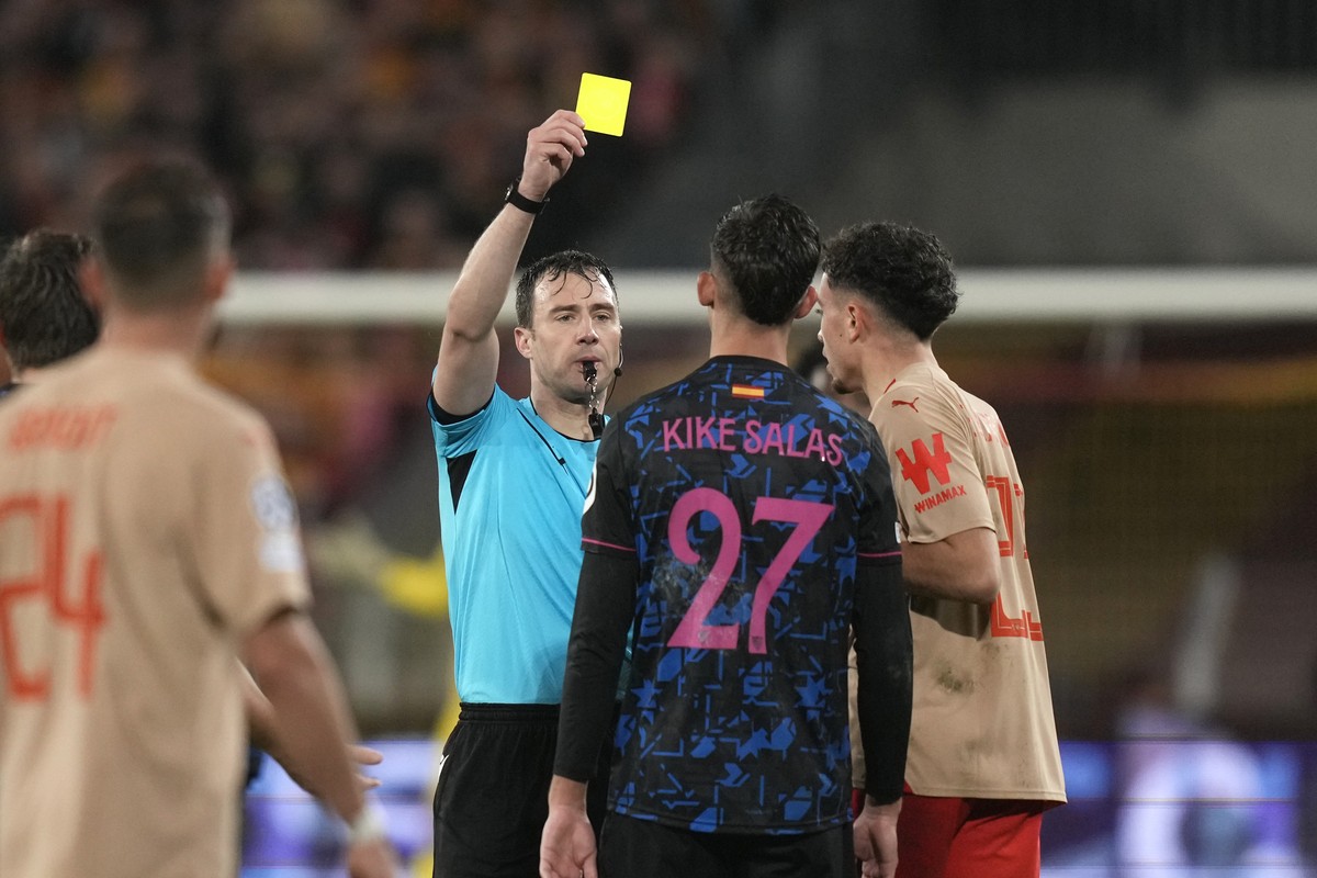 Referee Felix Zwayer shows a yellow card to Sevilla's Kike Salas during the Champions League Group B soccer match between Lens and Sevilla at the Bollaert stadium in Lens, France, Tuesday, Dec. 1 ...