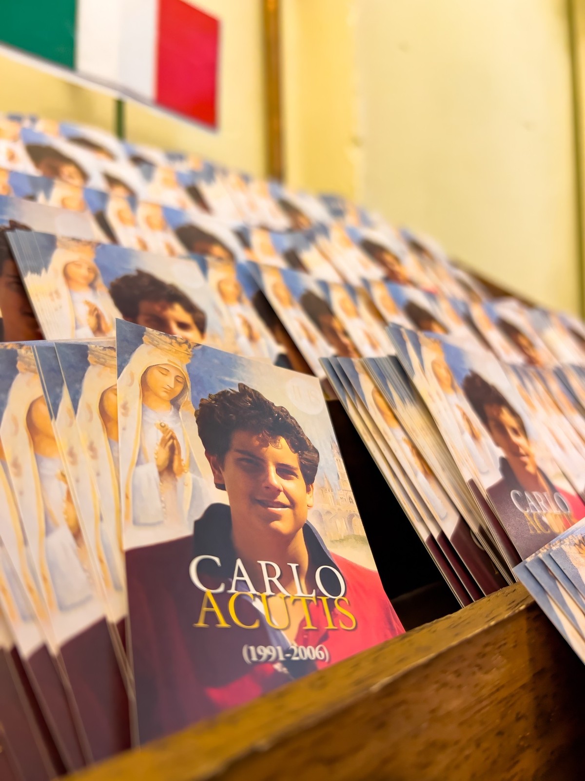 Kleine Plakate von Carlo Acutis mit dem Gebet zu ihm auf der Rückseite.