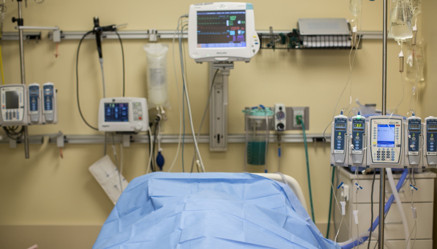 In this Friday, Feb. 21, 2014 photo, the body of a brain-dead potential organ donor lies covered on a bed at Mid-America Transplant Services in St. Louis. Removing organs at a central location near ho ...