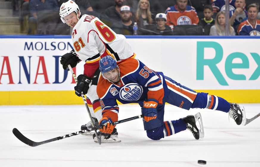 Calgary Flames &#039; Brett Kulak (61) checks Edmonton Oilers&#039; Ryan Vesce (59) during the first period of an NHL hockey preseason game Monday, Sept. 26, 2016, in Edmonton, Alberta. (Jason Franson ...