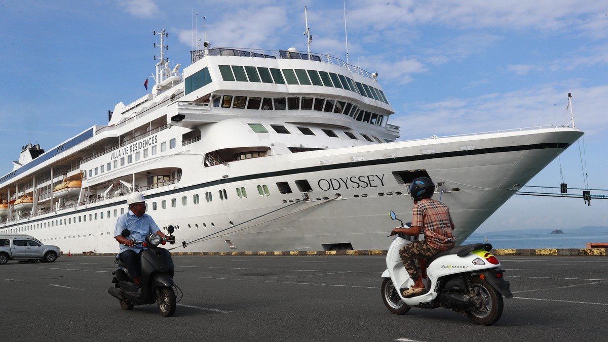 epaselect epa13337925 Workers drive past the cruise ship 'Odyssey', operated by Villa Vie Residences, docked at Sihanoukville port in Preah Sihanouk province, Cambodia, 29 October 2026. The  ...