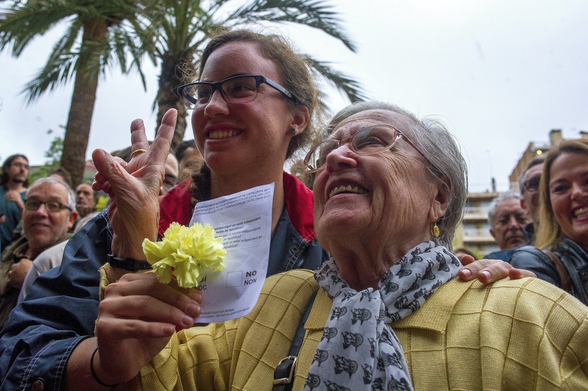 epa06237837 A woman shows her voting as she arrives to vote in the '1-O Referendum' in Sabadell, Barcelona, Catalonia, northeastern Spain, on 01 October 2017. Spanish National Police officer ...