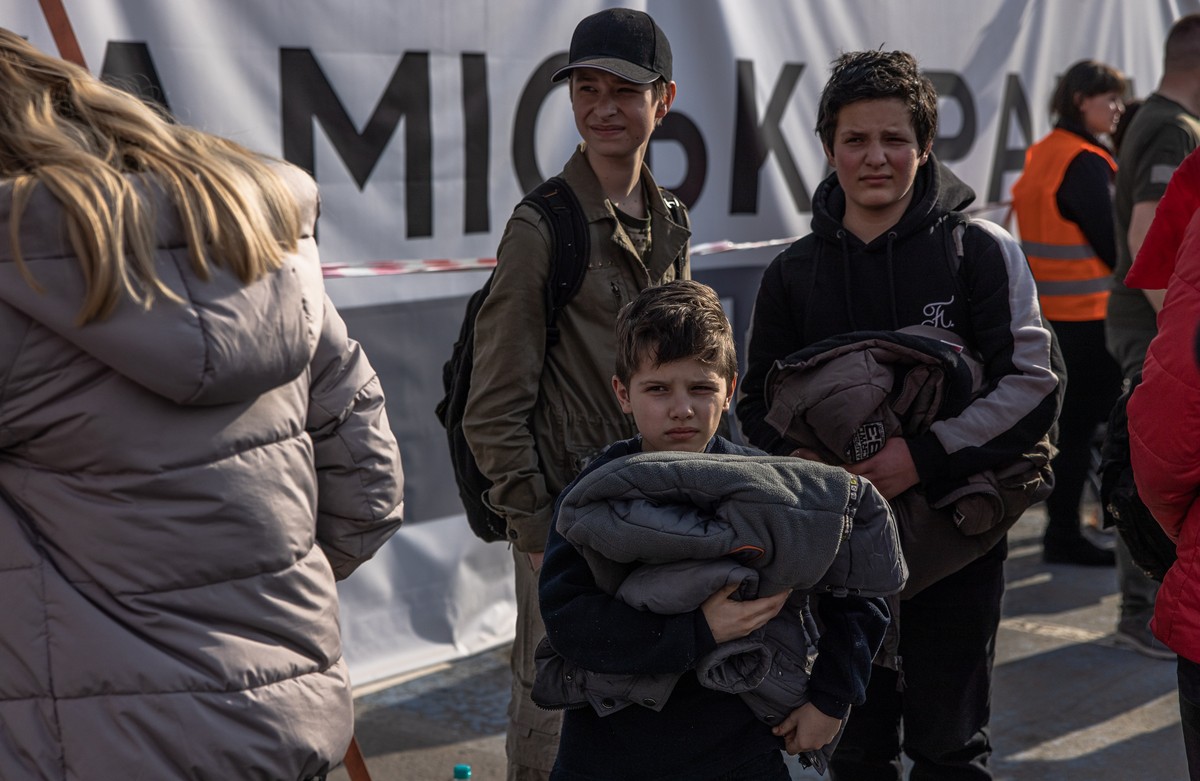 epa09924947 Slava (C) with his brother Volodymyr (R) who were evacuated from Mariupol?s steel plant Azovstal wait after arriving on a bus at the evacuation point in Zaporizhzhia, Ukraine, 03 May 2022. ...