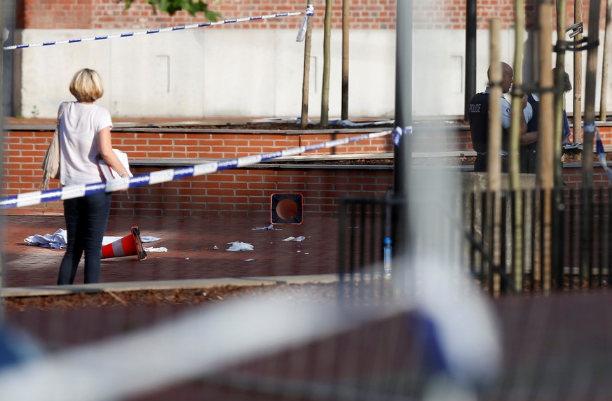 A woman stands at the site where a machete-wielding man injured two female police officers before being shot outside the main police station in Charleroi, Belgium, August 6, 2016. REUTERS/Francois Len ...