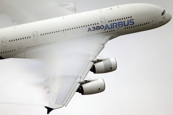 FILE - In this June 18 2015 file photo, vapor forms across the wings of an Airbus A380 as it performs a demonstration flight at the Paris Air Show, Le Bourget airport, north of Paris. Shares in Airbus ...