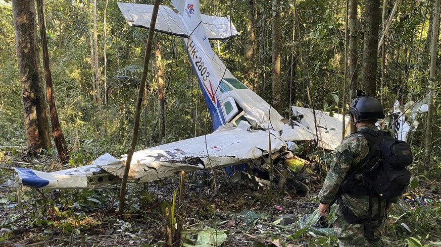 FILE - In this photo released by Colombia&#039;s Armed Forces Press Office, a soldier stands in front of the wreckage of a Cessna C206, May 18, 2023, that crashed in the jungle of Solano in the Caquet ...