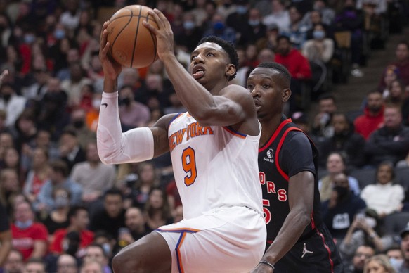 December 10, 2021, Toronto, ON, CAN: New York Knicks RJ Barrett, left, shoots on Toronto Raptors Chris Boucher during second half NBA, Basketball Herren, USA basketball action in Toronto on Friday, De ...