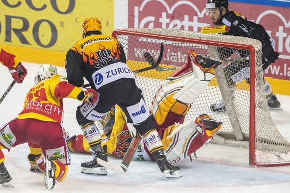 Lugano’s player Maxime Lapierre, left, fights for the puck with Biel&#039;s goalkeeper Jonas Hiller, right, during the second match the semifinal of National League Swiss Championship 2017/18 between  ...