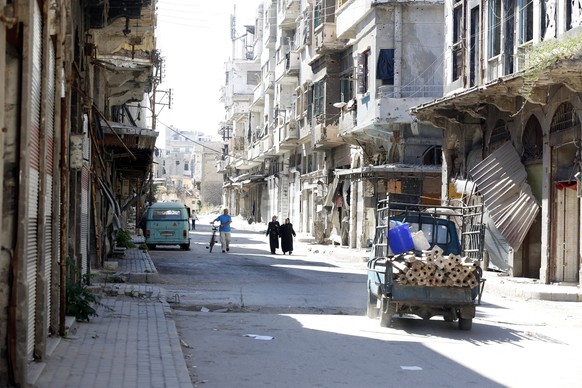 epa05548192 Syrians walk in the central city of Homs, Syria, 19 September 2016. According to media reports, the evacuation process of some 300 gunmen from the besieged neighborhood of al-Waer in Homs  ...