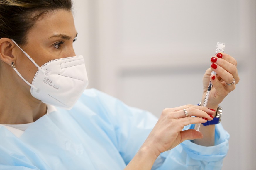 epa08926439 A medical staff member is administered the Pfizer-BioNTech COVID-19 vaccine during a medical staff members vaccination at the Batajnica Covid hospital in Belgrade, Serbia, 08 January 2021. ...