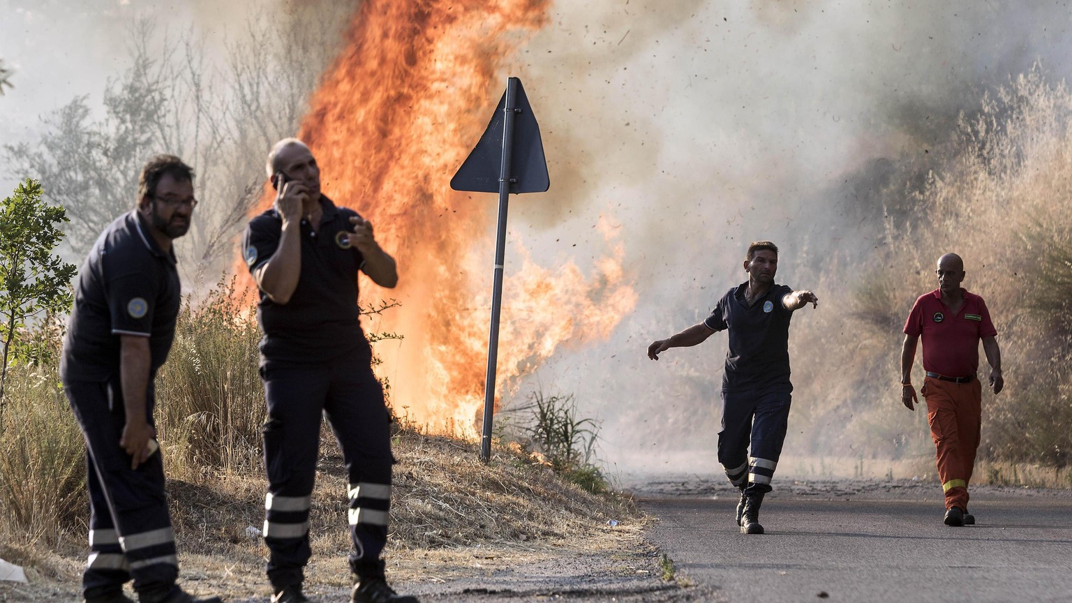 epa06085736 Civil Protection at work during the fire-extinguishing operation at San Pietro in Guarano, near Cosenza, southern Italy, 13 July 2017, where a 69-year-old man was burned to death by a wild ...
