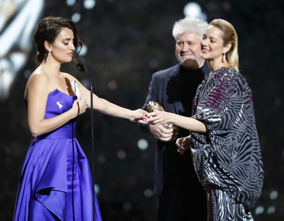 Spanish actress Penelope Cruz, left, reacts as she receives an Honorary Cesar award from Spanish director Pedro Aldomovar, center, and French actress Marion Cotillard during the ceremony of 43rd Cesar ...