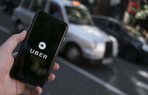 epa06219391 An Uber logo on a mobile telephone in central London, Britain, 22 September 2017. Transport for London (TFL), the governing body responsible for transport in London, announced on 22 Septem ...