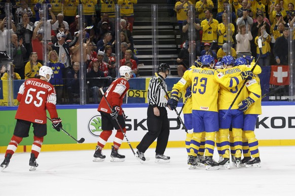 Sweden&#039;s players celebrates their goal past Switzerland&#039;s players defender Ramon Untersander, left, and defender Dean Kukan, 2nd left, after scoring the 0:2, during the IIHF 2018 World Champ ...