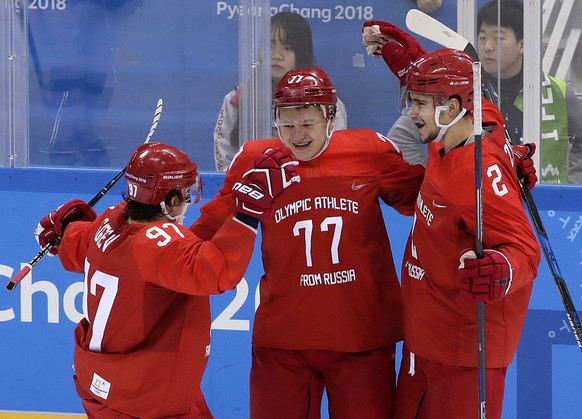 Russian athlete Kirill Kaprizov (77) celebrates with Nikita Gusev (97) and Artyom Zub (2) after scoring a goal during the third period of the preliminary round of the men&#039;s hockey game against Sl ...