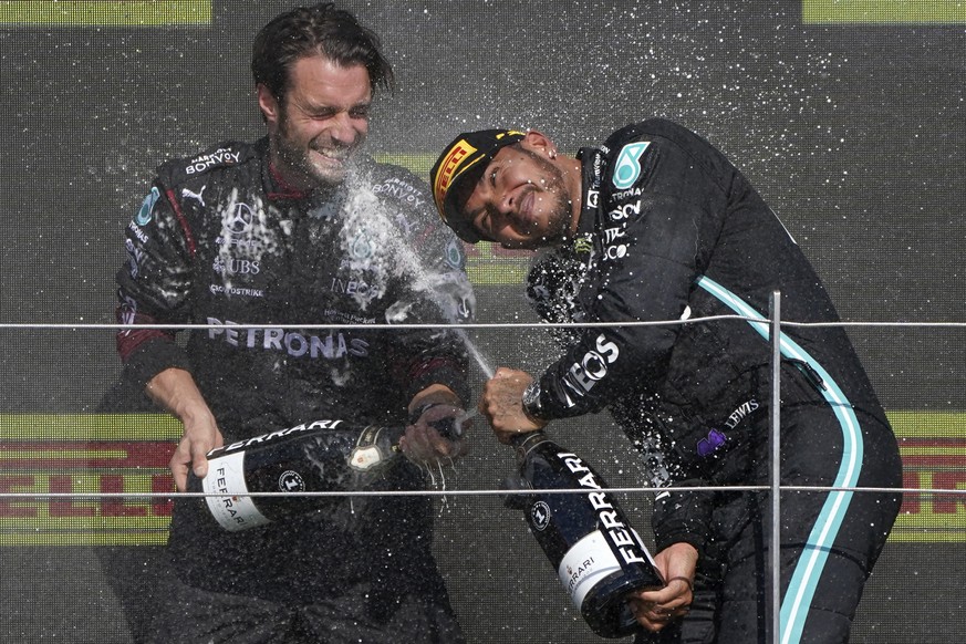 Mercedes driver Lewis Hamilton of Britain, right, celebrates on the podium after winning the British Formula One Grand Prix, at the Silverstone circuit, in Silverstone, England, Sunday, July 18, 2021. ...