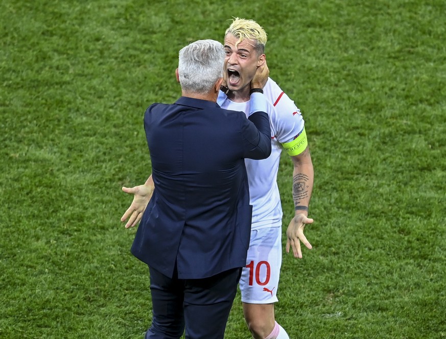 Switzerland's Granit Xhaka celebrates with manager Vladimir Petkovic after defeating France in a penalty shoot out during the Euro 2020 soccer championship round of 16 match between France and Sw ...