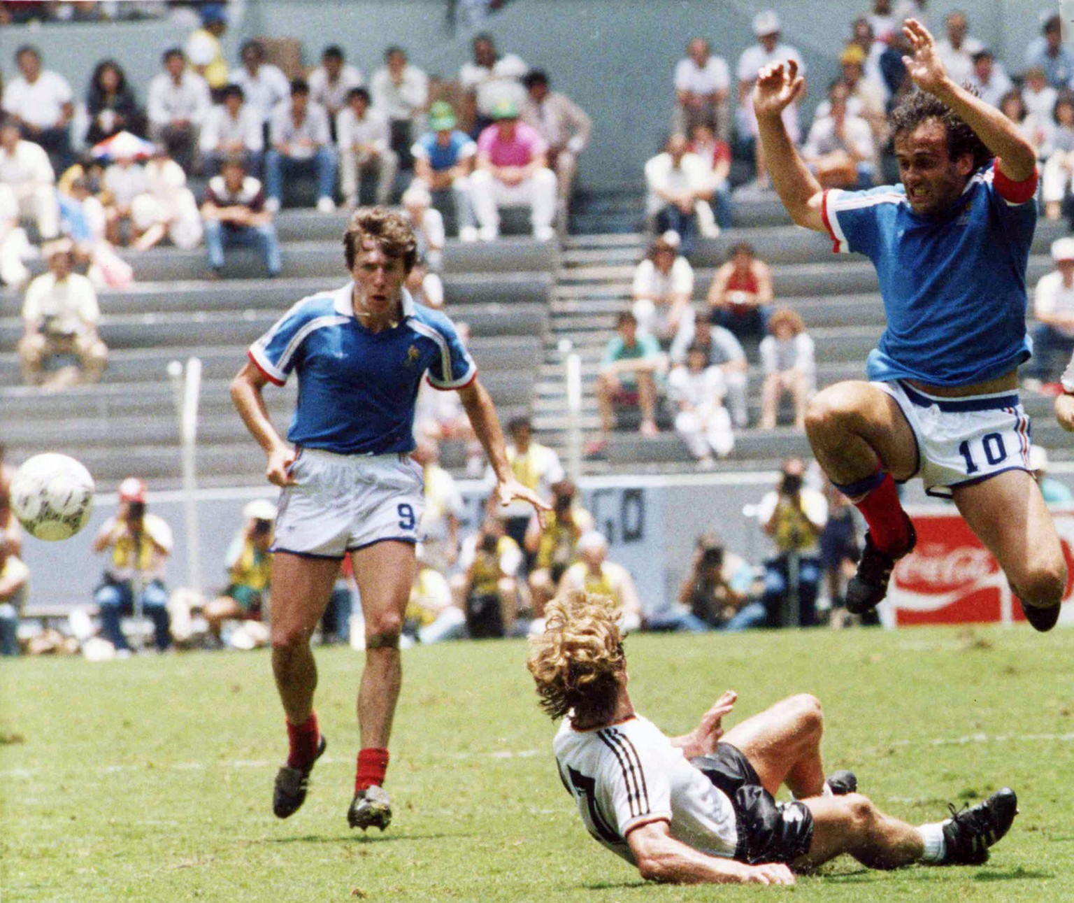 France&#039;s Michel Platini, right, jumps over Germany&#039;s Ditmar Jakobs during the Football World Cup Semi-Final in Guadalajara, Mexico, on June 25, 1986. French defender Luis Fernandez, left, wa ...