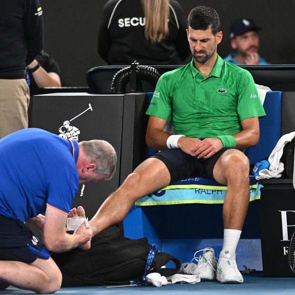 epa12676893 Novak Djokovic of Serbia receives medical attention during the Mens 3rd round match against Botic Van De Zandschulp of Netherlands on day 7 of the 2026 Australian Open tennis tournament i ...
