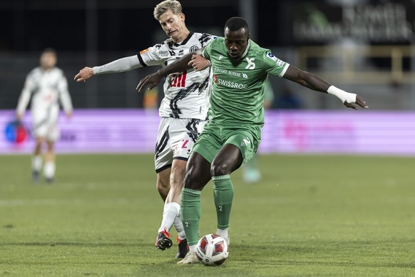 CAPTION CORRECTION: CORRECTS IDENTITY OF YVERDON PLAYER - Le milieu luganais Roman Macek, gauche, lutte pour le ballon avec le defenseur yverdonnois Mohamed Tijani, droite, lors de la rencontre de foo ...