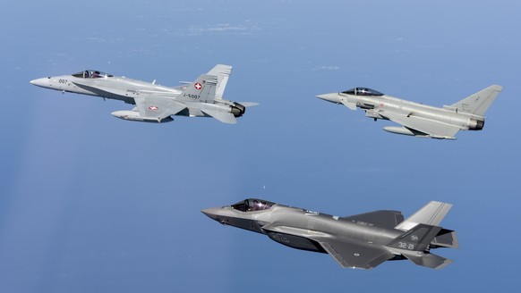 HANDOUT - Un avion F/A-18 de l&#039;Armee Suisse, gauche, et un F-35, droite en bas, et un Eurofighter, droite en haut, de l&#039;Armee italienne, droite en bas, sont photographies lors de la journee  ...