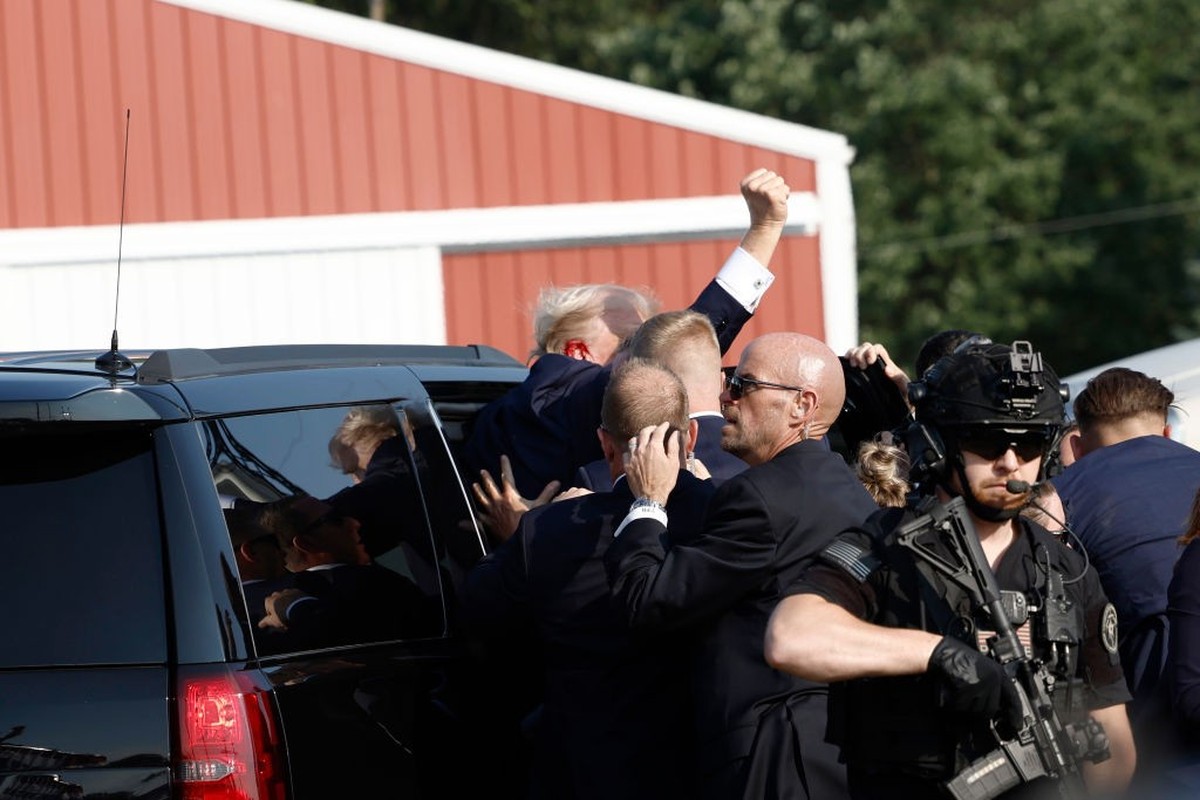 BUTLER, PENNSYLVANIA - JULY 13: Republican presidential candidate former President Donald Trump pumps his fist as he is rushed offstage during a rally on July 13, 2024 in Butler, Pennsylvania. Butler  ...