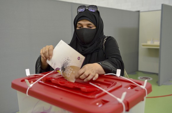 epa09501508 Qatari woman wearing a niqab casts her vote at a polling station in Doha, Qatar, 02 October 2021. Qatar is holding its first legislative elections on 02 October, to elect 30 of the 45 memb ...