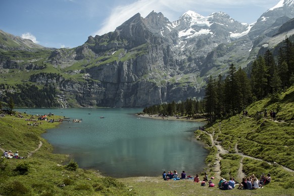 epa04342805 Toursits make the most of the weather in the mountains near lake Oeschinensee next to Kandersteg, canton Bern, Switzerland, 06 August 2014. The Alpine lake is situated at 1,578 meter above ...